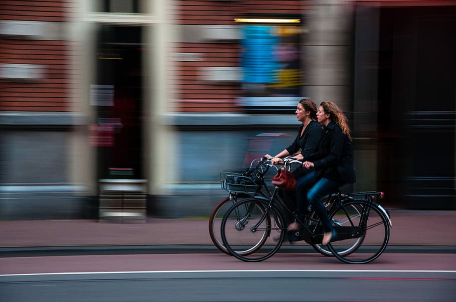 time lapse photography of two person riding bicycle, two women riding city bicycles, HD wallpaper