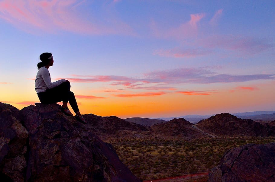 woman sitting on brown rock monolith, sunset, sunrise, sky HD wallpaper