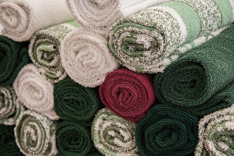 close-up photo of assorted-color rolled rug lot, towels, washday