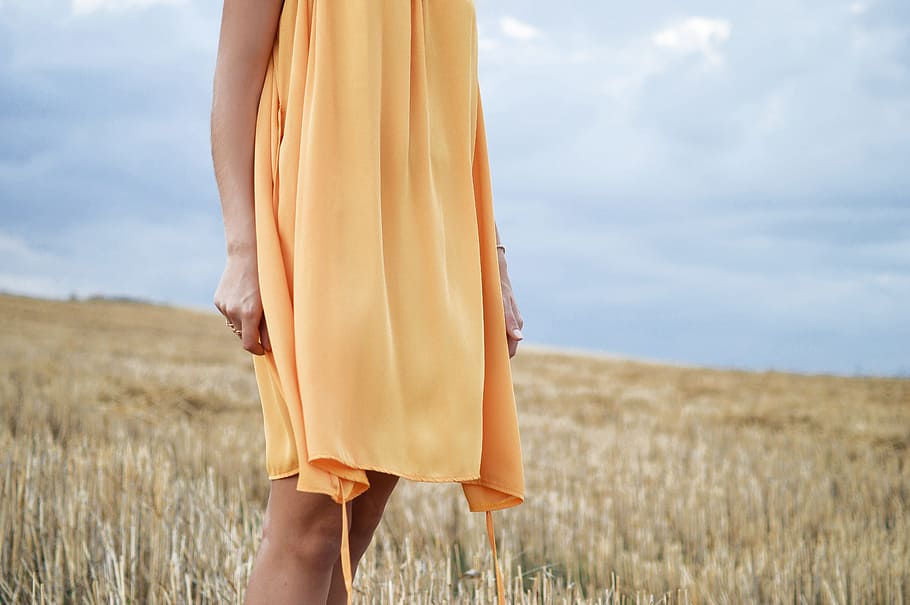 woman wearing yellow dress standing on green grass field, woman wearing yellow dress standing between field HD wallpaper