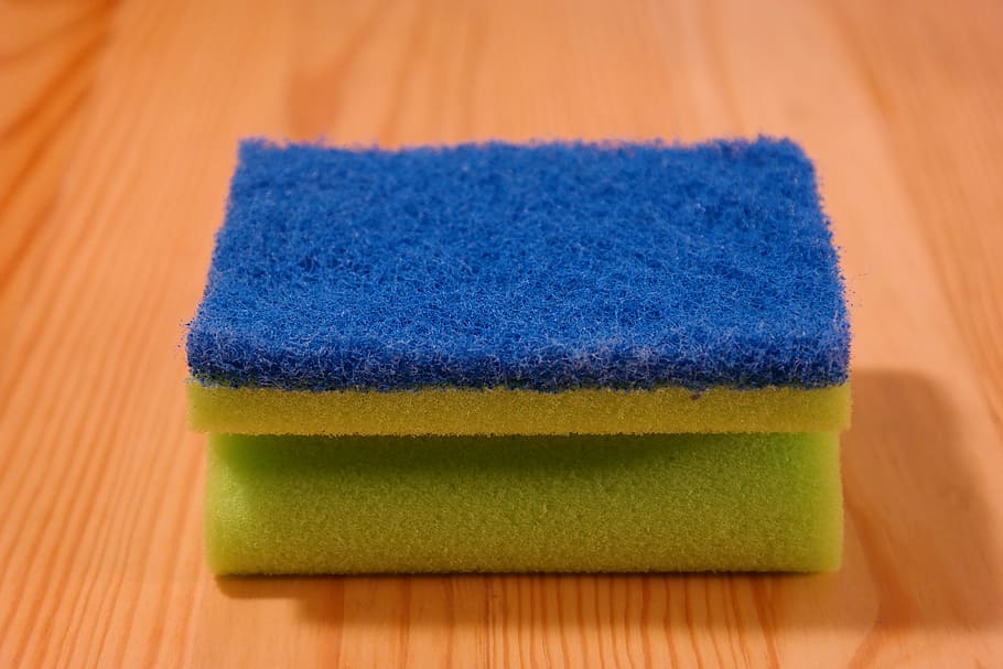 blue and yellow sponge on brown wooden surface, clean, rinse