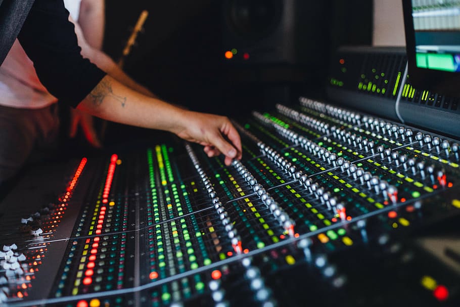 closeup photography of person using mixing console, control panels
