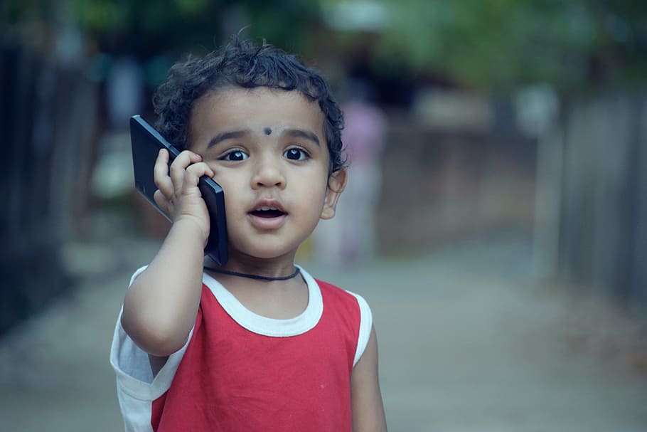 shallow focus photography of toddler in red top holding black smartphone, HD wallpaper