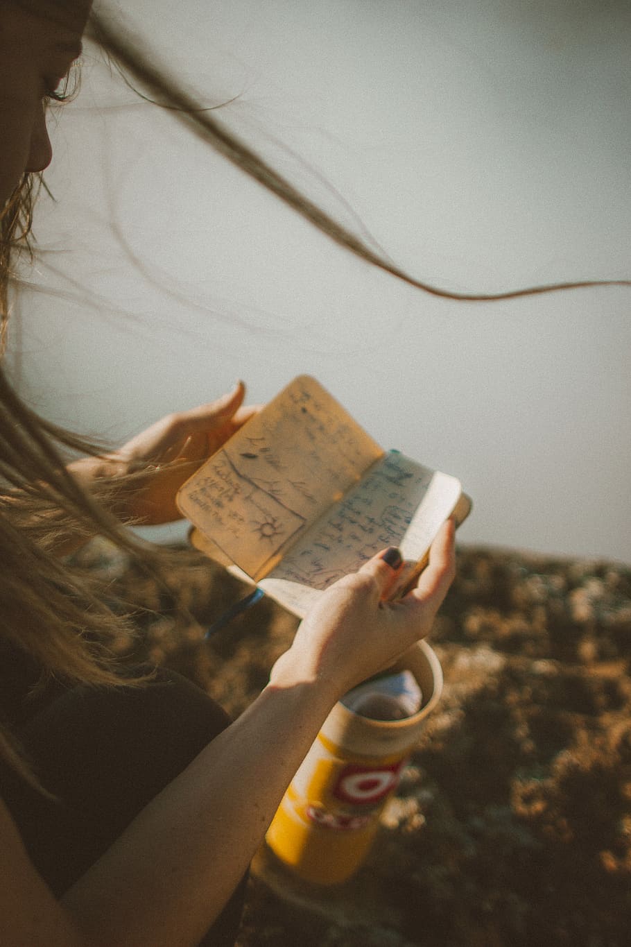 woman reading notebook, person reading book while standing near wall HD wallpaper