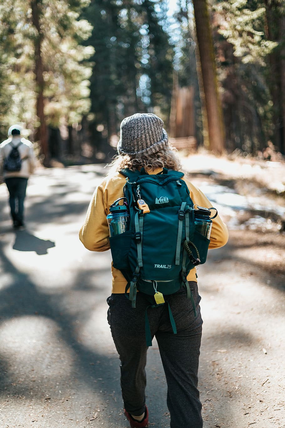 person wearing yellow shirt walking towards with man on concrete road during daytime, tilt-shift photography of woman carring backpack HD wallpaper