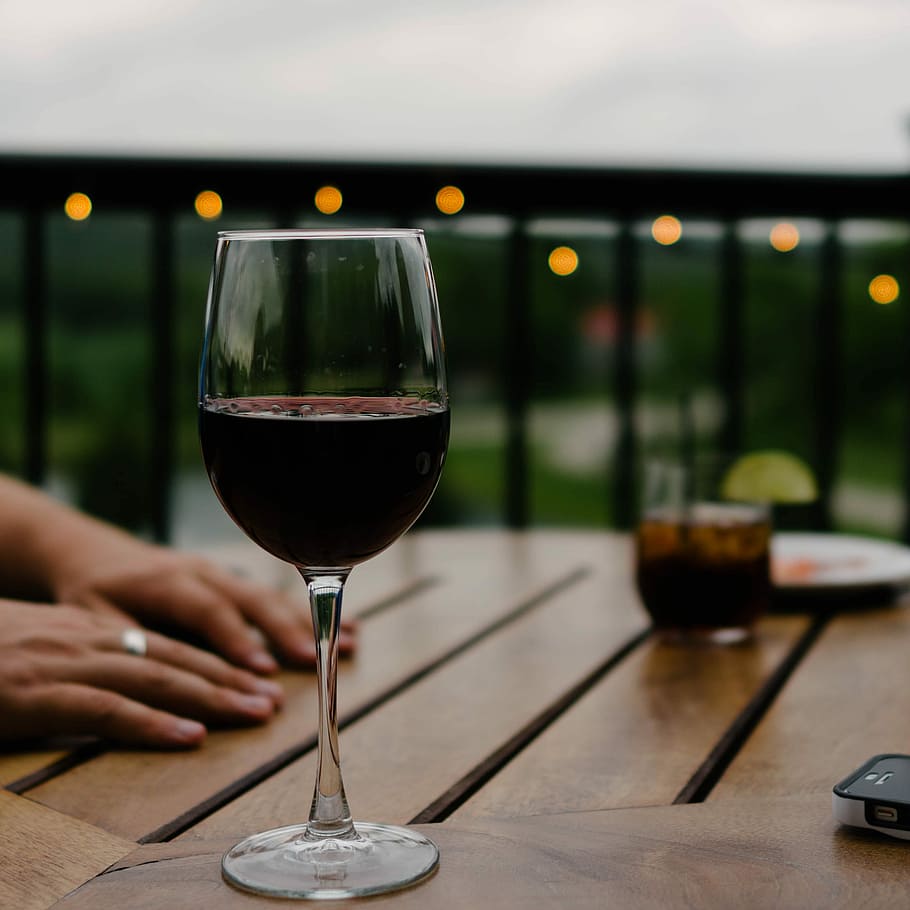 person hand on top of a table, selective focus photography of wine glass with stein on table HD wallpaper