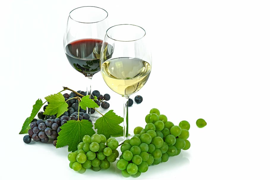 two wine glasses surrounded by grapes, white, red, an isolated