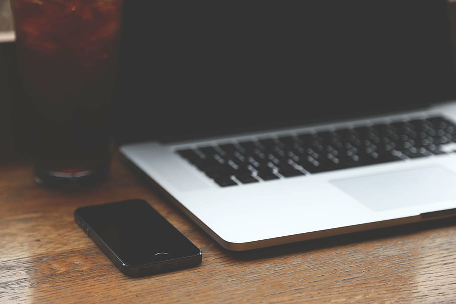 turned-off iPhone beside MacBook on table, pro, space, gray HD wallpaper