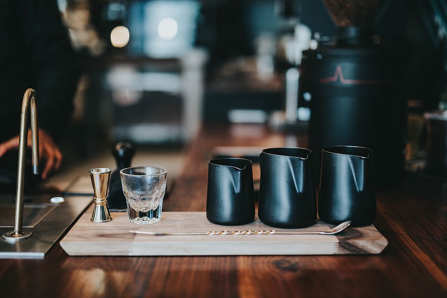 three black milk jars on brown table, three black ceramic pitchers HD wallpaper