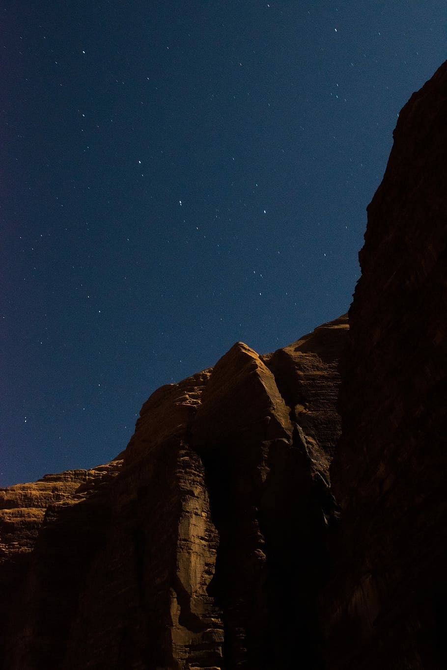 brown canyon during night time, brown rock mountain under dark sky