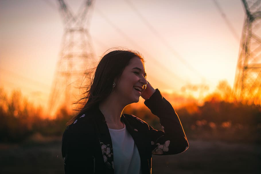 woman smiling during daytime, woman laughing at someone during sunset