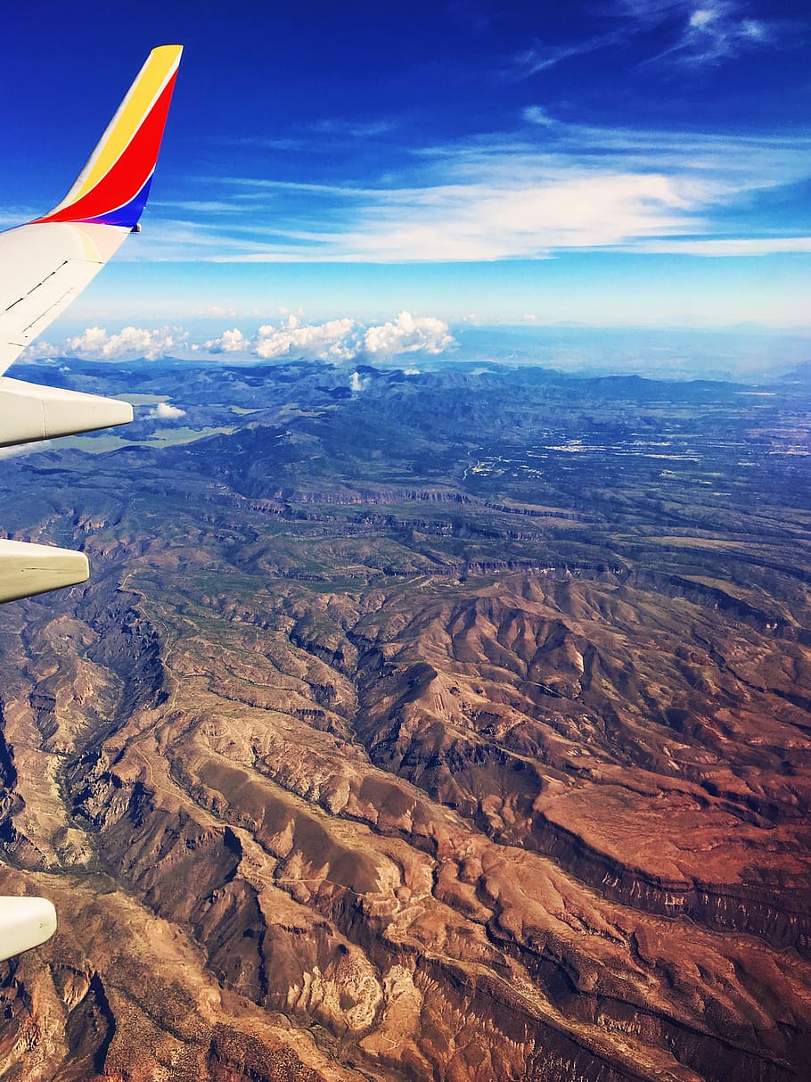 airliner passing through canyon, aerial view photography of brown mountains HD wallpaper