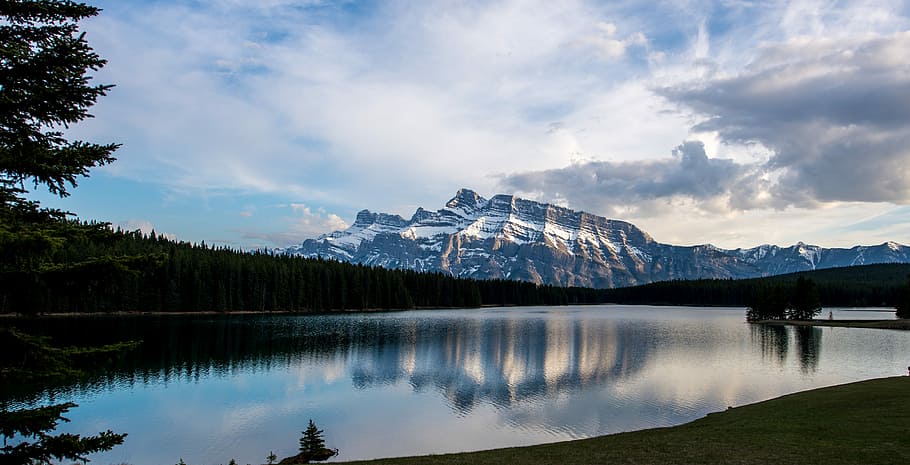 photo of mountain range covered with snow, paronamic photography of mountain reflecting on body of water HD wallpaper