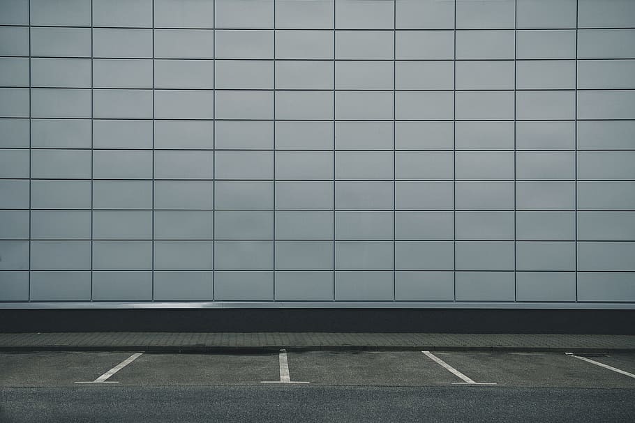 Greys, empty parking space near white building wall, flooring
