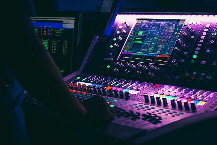 person playing the audio controller, man using purple audio mixer