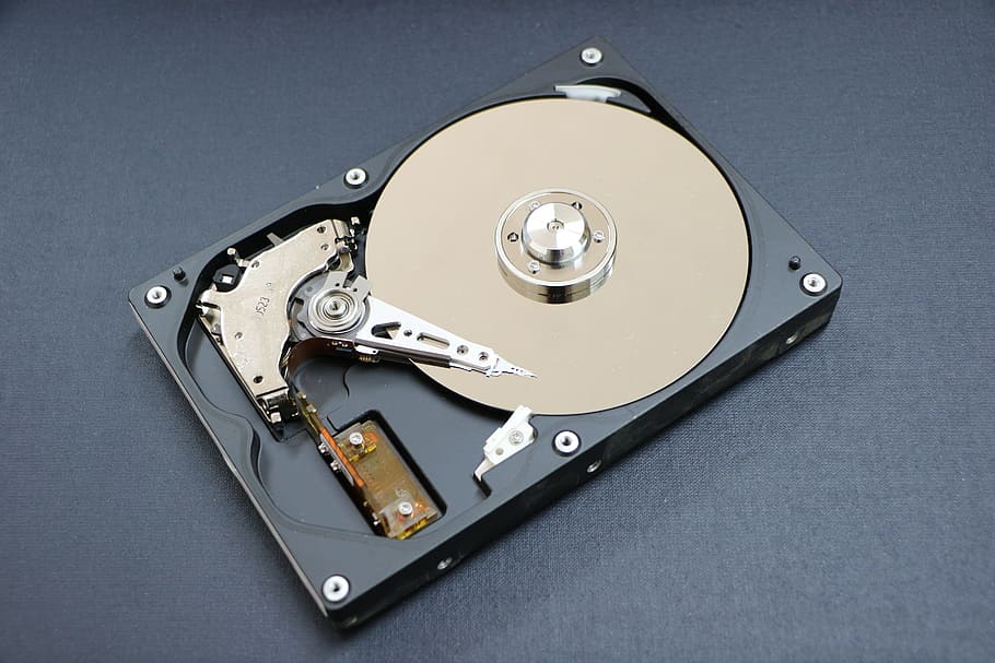 black and silver CD lens on black surface, hard disk, a hard disk drive