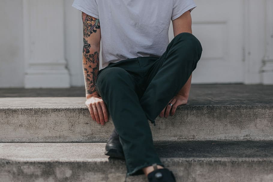 person sitting on gray concrete flooring, person in black pants sitting on stair during dayime HD wallpaper