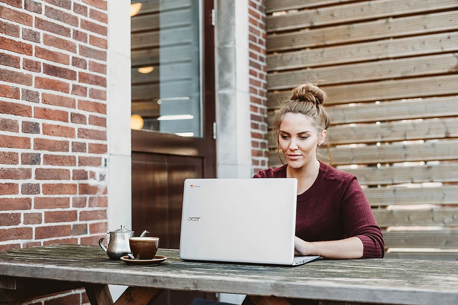 woman sitting and holding white Acer laptop near brown wooden wall, woman using white Acer laptop HD wallpaper