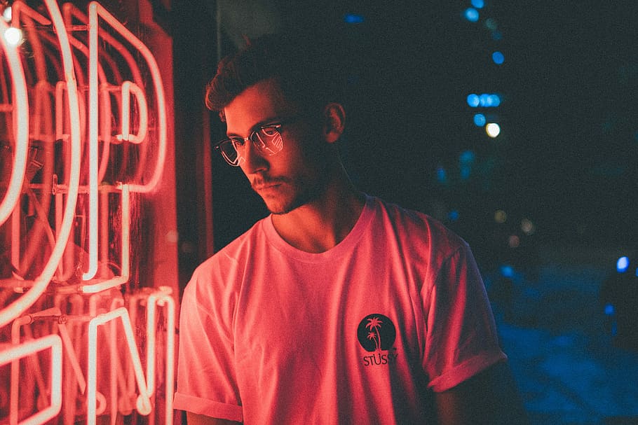 man standing in front of pink neon light signage, man standing near neon signage during night time HD wallpaper