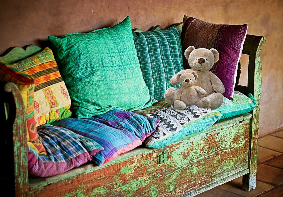 assorted-color throw pillows and two brown bear plush toys, sofa