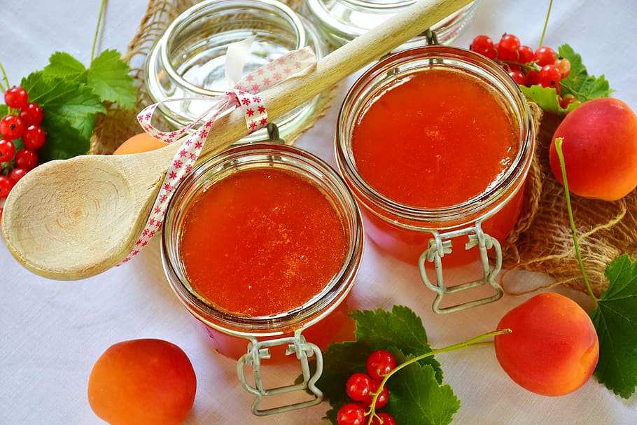 two clear glass jars beside brown wooden spatula, jam, apricots HD wallpaper