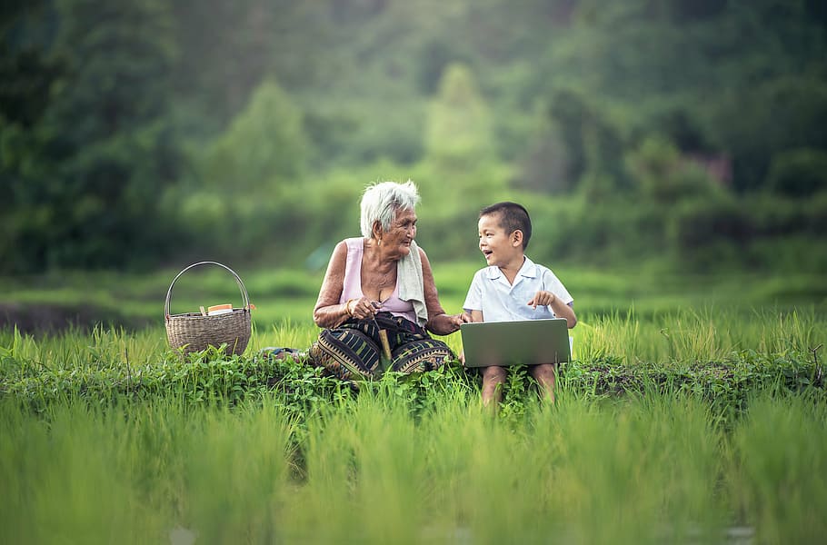 boy with laptop sitting beside white haired woman on green field, HD wallpaper