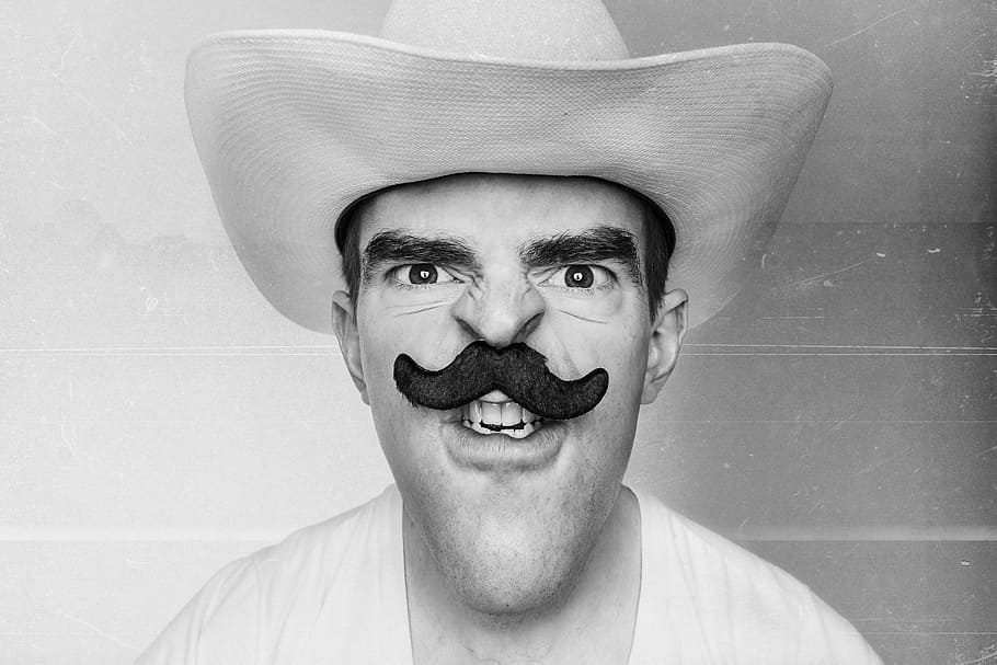 grayscale photography of man in cowboy hat with mustache, people