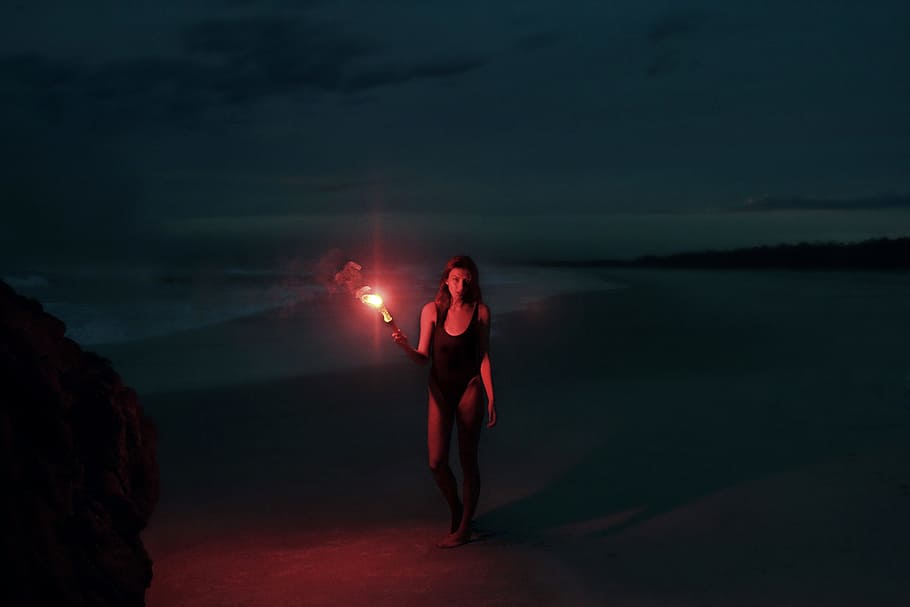 woman in one-piece swimsuit holding torch, In the Mystery, flare