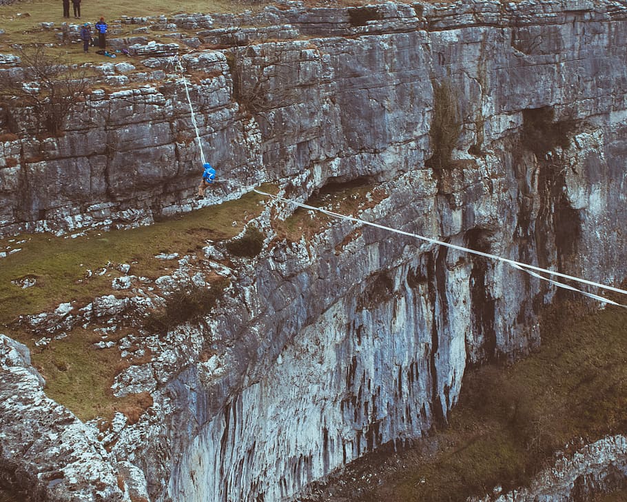 aerial view photography of person doing rope balancing, person crossing the rope during daytime HD wallpaper