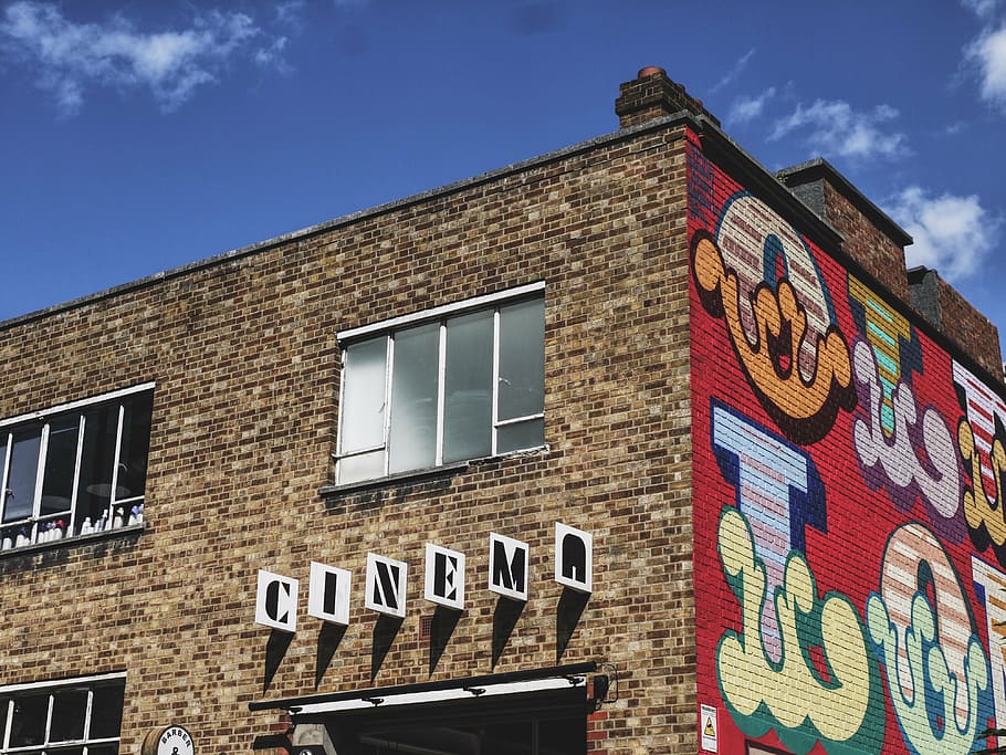 Cinema building under blue sky, signage, brown, bricked, wall HD wallpaper