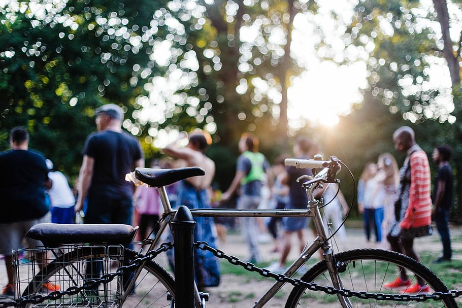 focus photo of commuter bike parked on rail, people playing at the park HD wallpaper