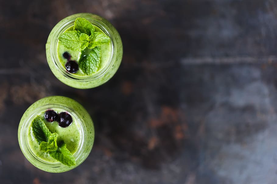 two green basil leaves on glass jars, top view, closeup, vegetarianism