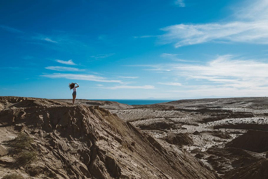 woman standing on fault block mountain during daytime, woman standing on cliff HD wallpaper