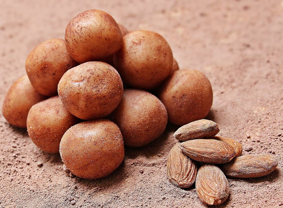 almond nut near round brown seed, marzipan potatoes, sweet goods