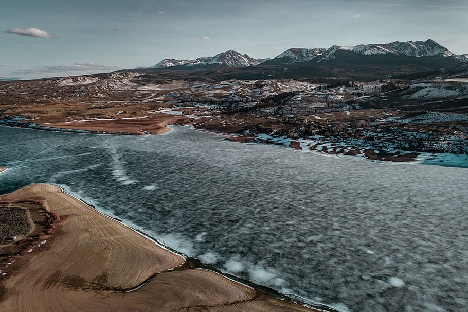aerial photography of river near mountain, brown mountain during daytime HD wallpaper