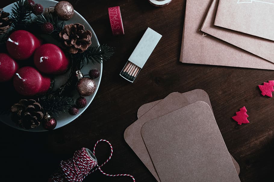 white matchbox beside gold bauble, four candles on plate, safety matchsticks, and string on table HD wallpaper