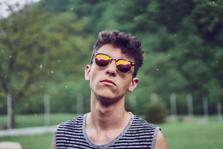 man standing wearing sunglasses, shallow focus of man standing outdoors during daytime HD wallpaper