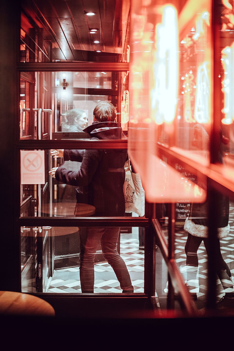 man standing near glass wall, person can be seen through window with brown wooden frames HD wallpaper