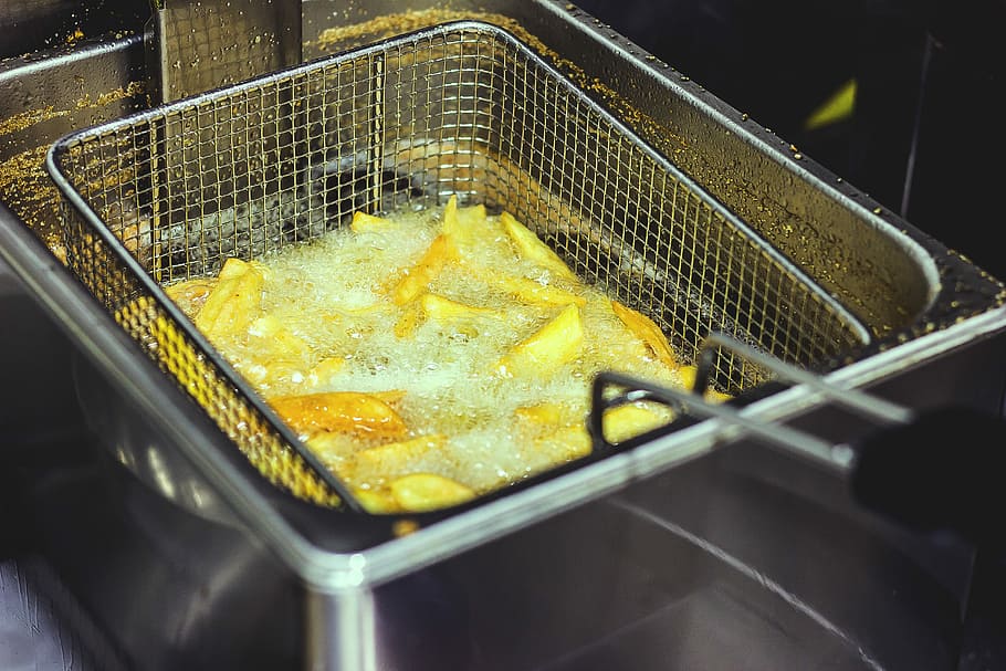 slice potatoes cook in deep fryer, potato fires in basket dipped on boiling oils