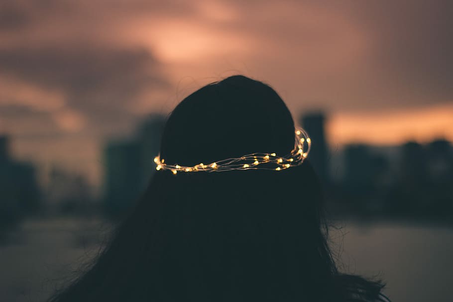 Lost in Sadness, woman wearing white string light crown at night time