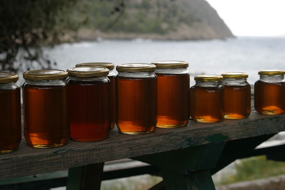 clear glass jars filled with brown liquid, honey, bench, coast HD wallpaper