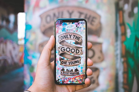 black Android smartphone, person holding silver iPhone X with only the good die young photo HD wallpaper