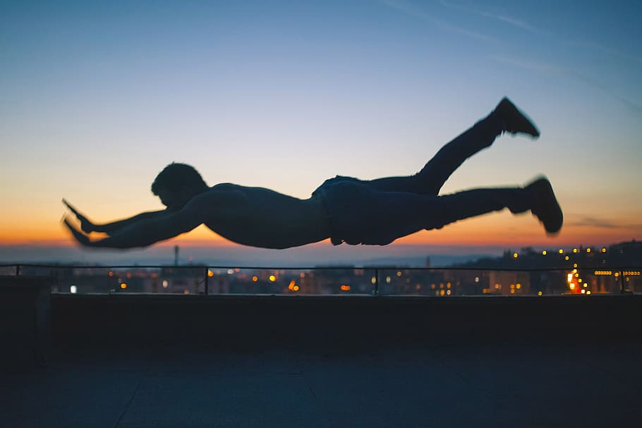 gray scale photo of man falling during golden hour, man planking on top of the building HD wallpaper