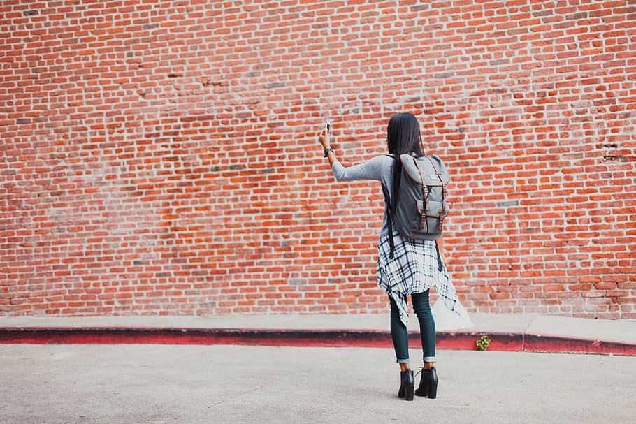 girl wearing backpack standing near orange brick wall, bricks HD wallpaper