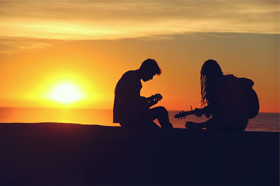 silhouette of two men playing guitars, man, woman, seashore, sunset