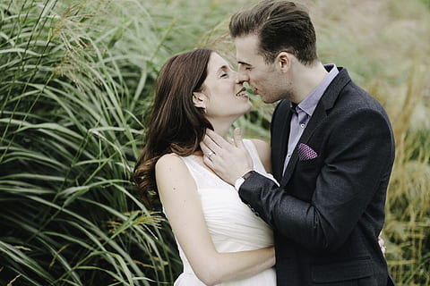 couple loved, man and woman stancing to kiss beside green grass plant HD wallpaper