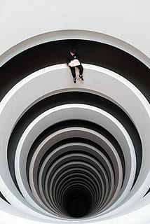 man sitting on deep pit design, man sitting on rail reading book HD wallpaper