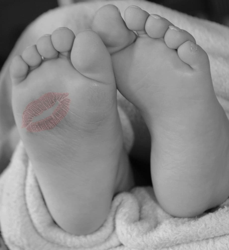 selective color photography of red kiss mark on foot, feet, baby