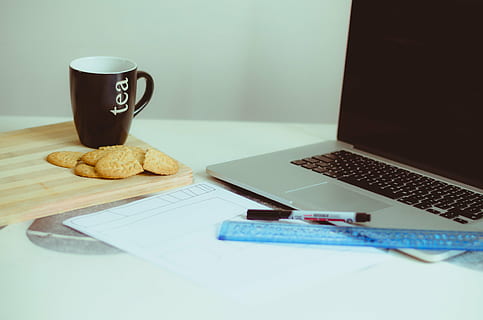 brown ceramic mug beside cookies near gray laptop computer on white surface HD wallpaper