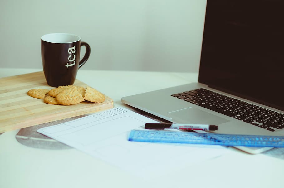 brown ceramic mug beside cookies near gray laptop computer on white surface HD wallpaper